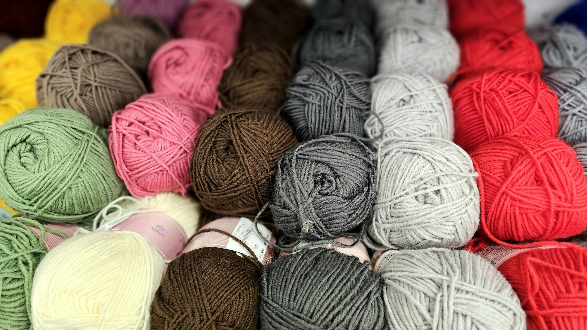 An array of colorful yarn balls perfect for knitting, crochet, and crafting enthusiasts.